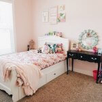 Little girls room with wall decor above the bed.